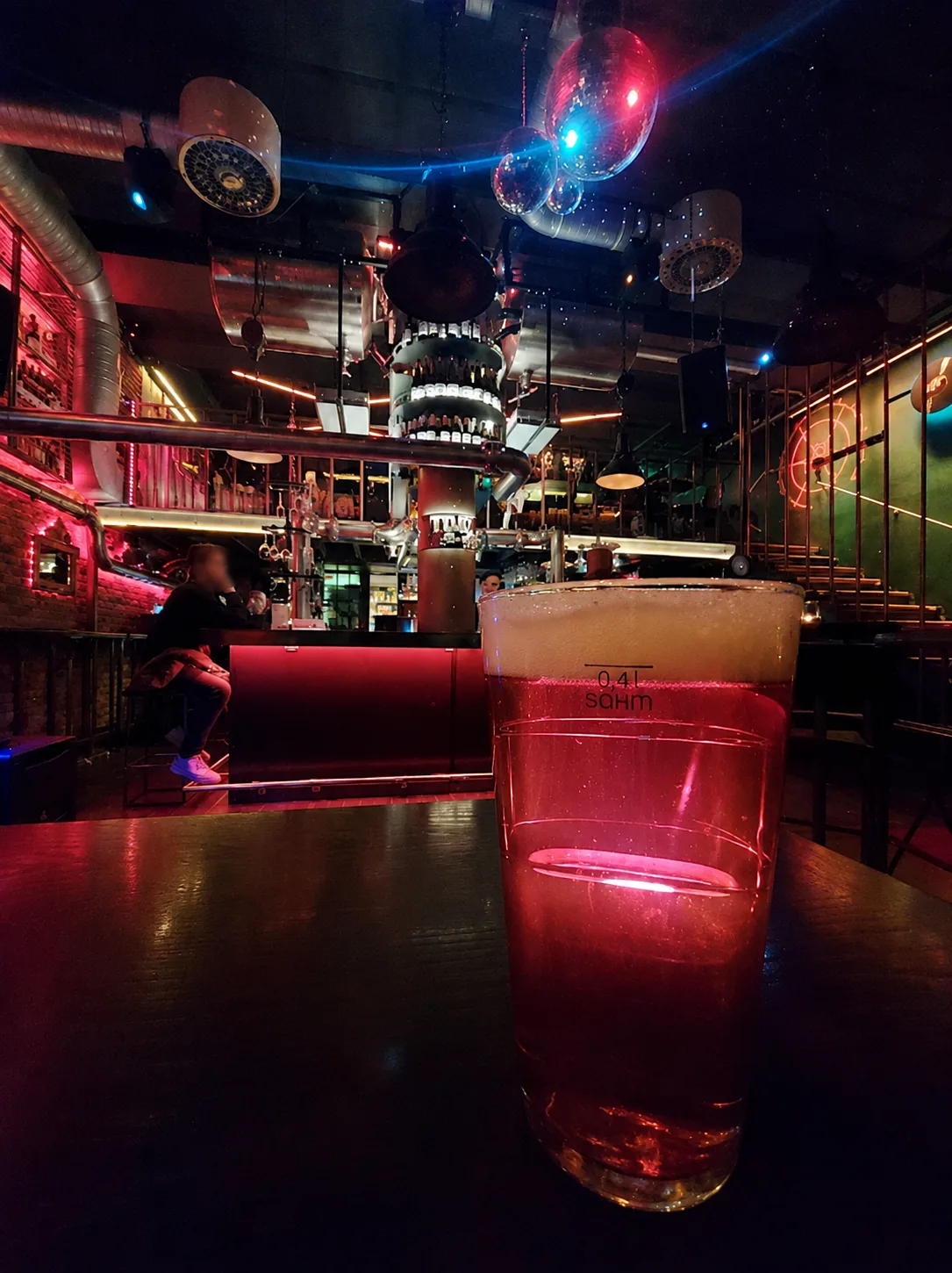 Ett glas i förgrunden med TIME:s bar, flasktorn och spegelkulor bakom