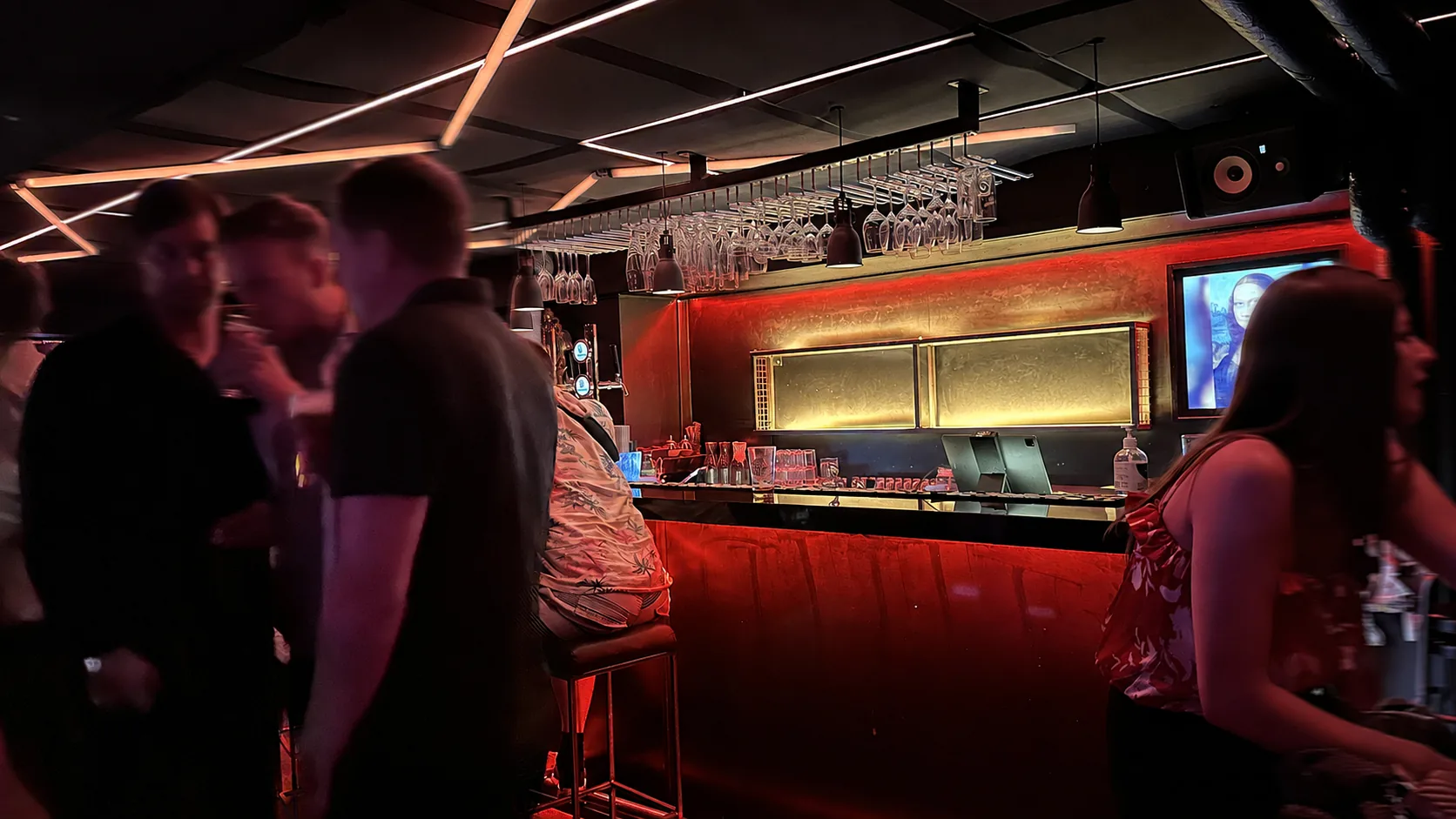 Baren på TIME:s övre våning med glasrader, varm belysning och gäster i rörelse
